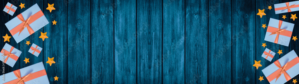 Festive Christmas / Advent background banner panorama - Top view / above view from gift boxes with ribbon, stars and bokeh lights, on rustic blue wooden boards, wood table texture Festive Christmas / Advent background banner panorama - Top view / above view from gift boxes with ribbon, stars and bokeh lights, on rustic blue wooden boards, wood table texture