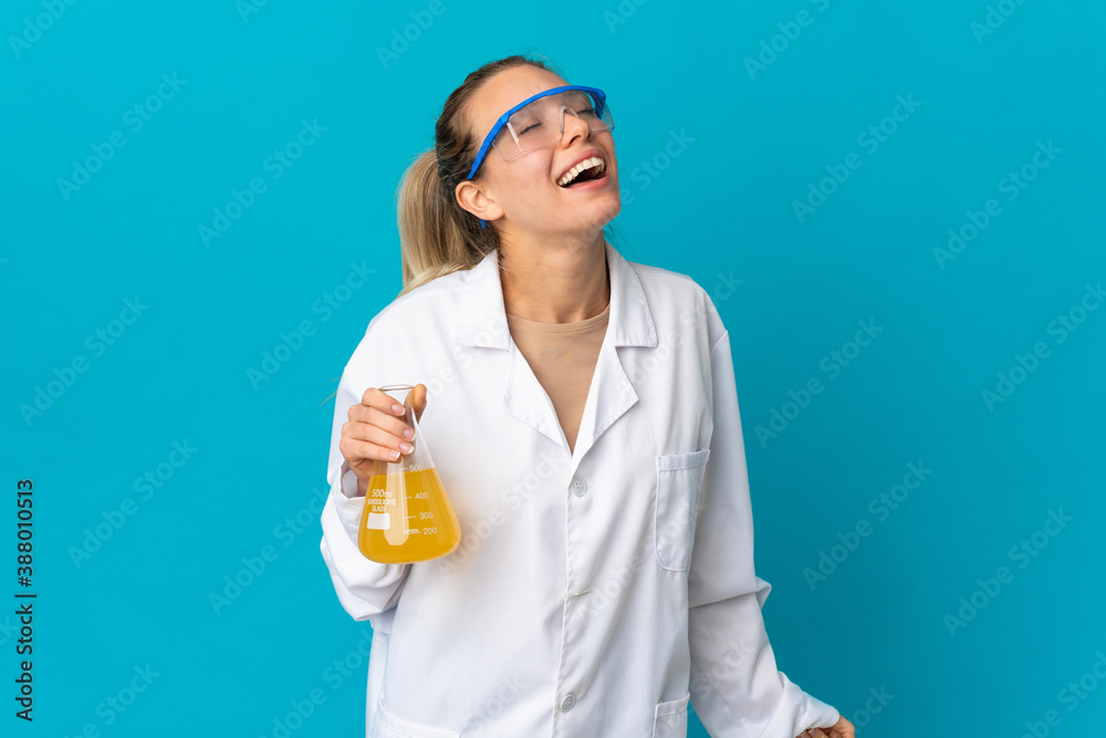 Young scientific woman isolated on blue background laughing Young scientific woman isolated on blue background laughing