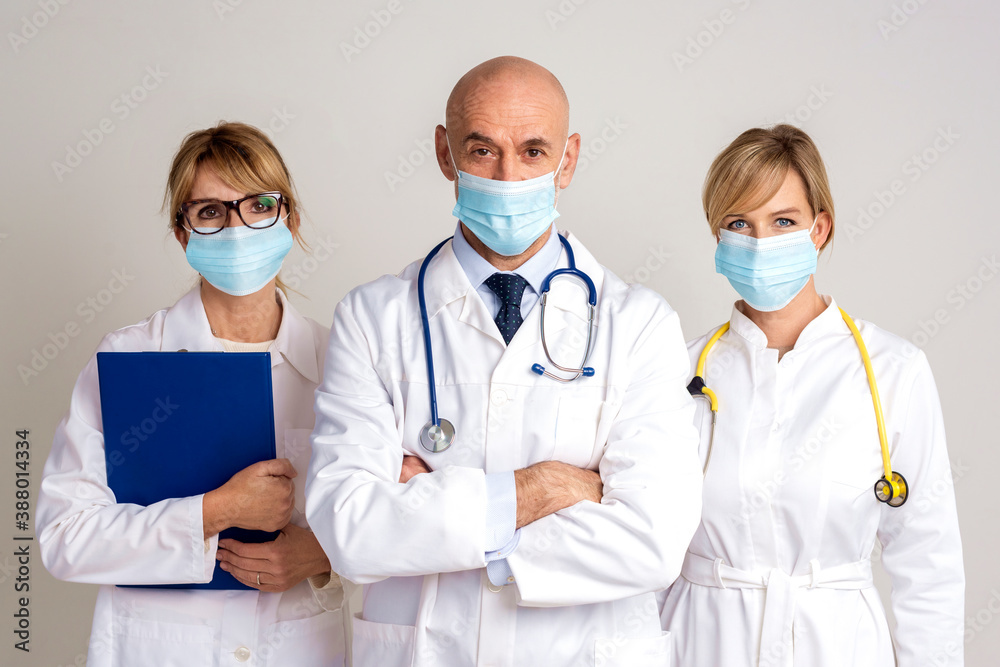 Shot of medical team standing together at isolated grey background