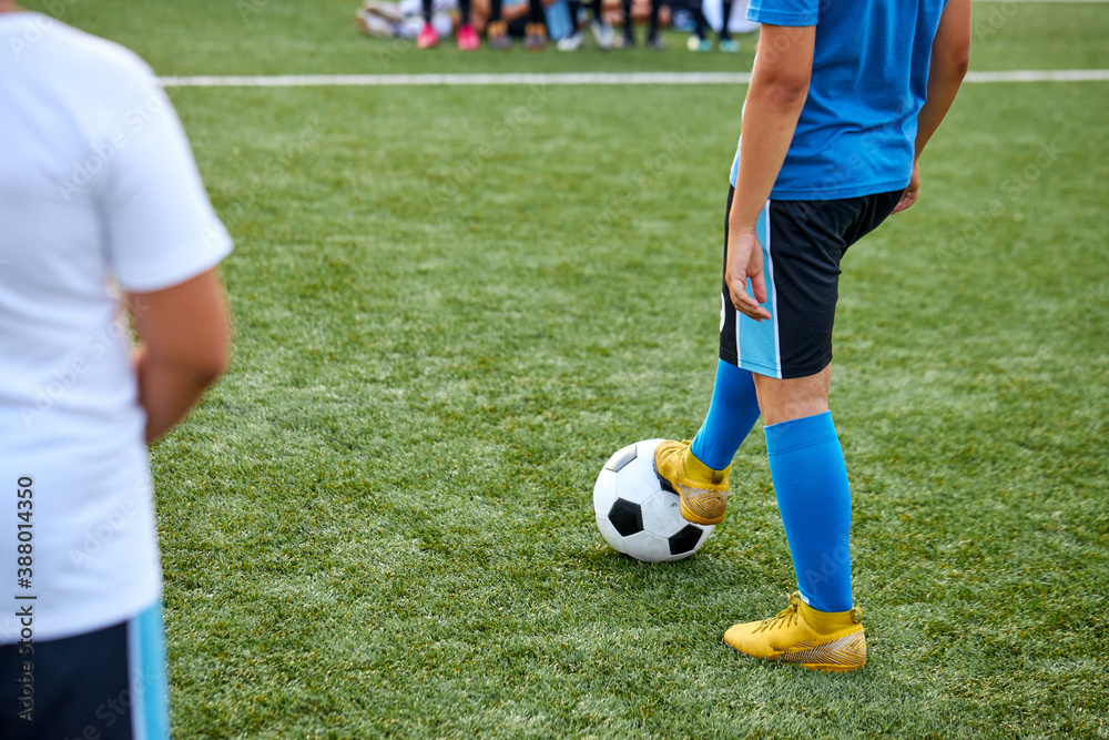Obraz premium sportive child boy in uniform kicking ball, they have penalty in this round. kids play football, competition in stadium, in field