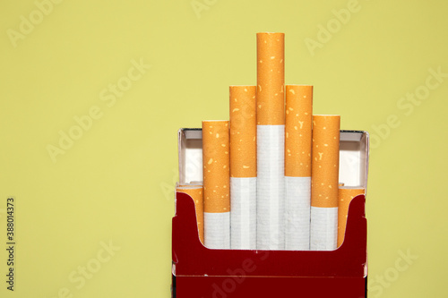 top view of an opened packet with tobacco filter cigarettes,  on yellow  background