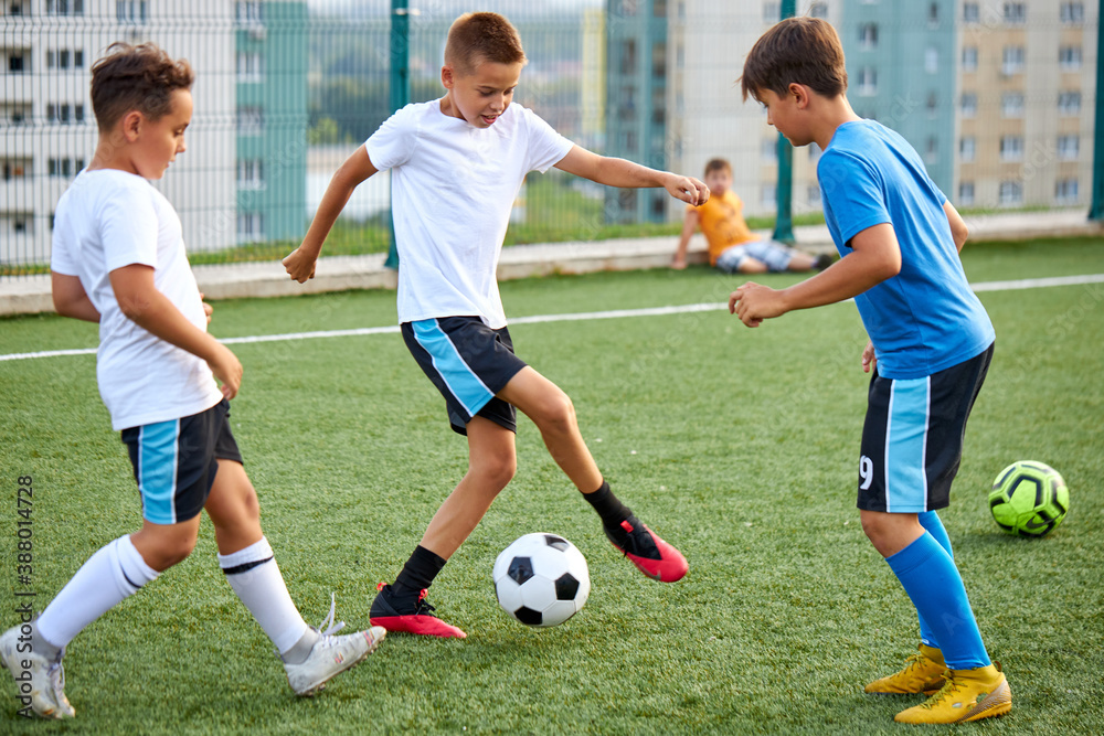 training and football match between youth soccer teams in stadium, boys have hard competition, running and kicking soccer ball