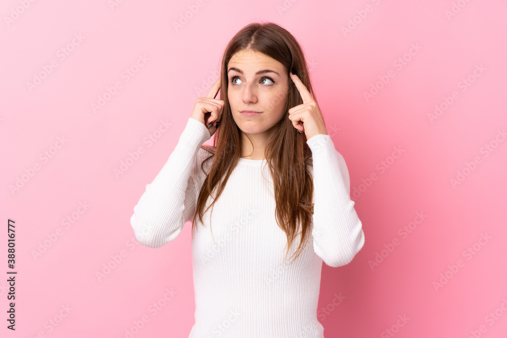 Young woman over isolated pink background having doubts and thinking