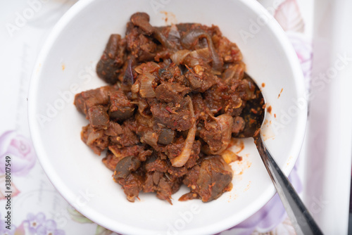A picture of a locally prepared dish made up of spicy peppered goat known as Asun photo