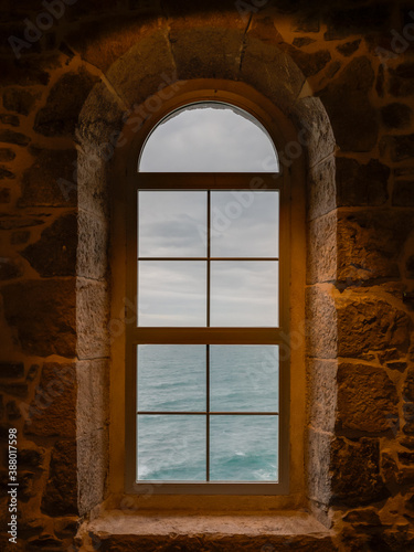 Window of an old lighthouse, view over the ocean. San Vicente de la Barquera, Cantabria, Spain