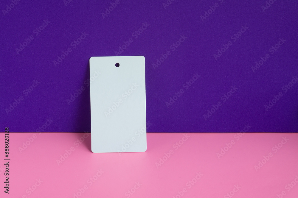 One white paper empty label on pink and purple background One white paper empty label on pink and purple background