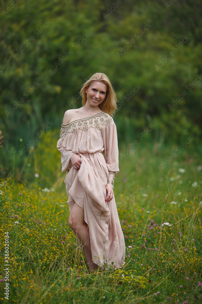 Fototapeta premium beautiful girl walking in a blooming field