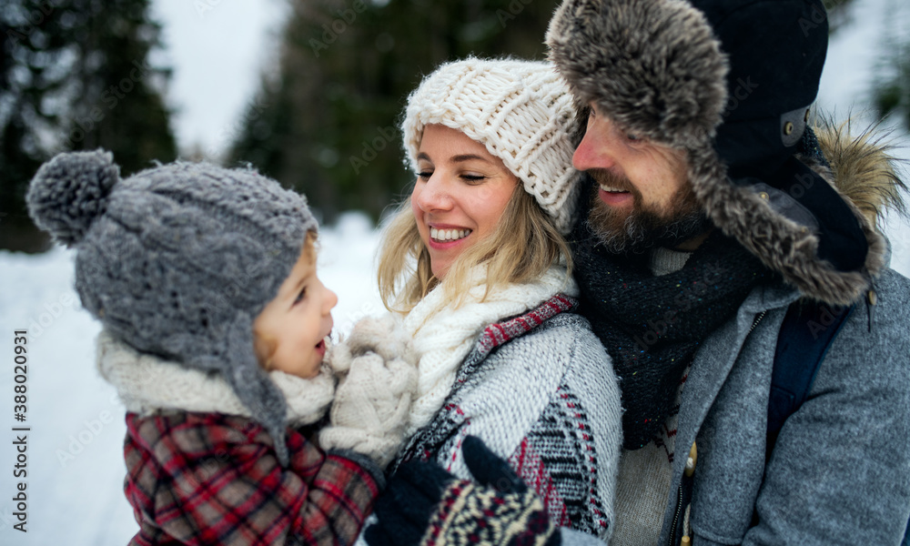 Father and mother with small child in winter nature, standing in the snow. Father and mother with small child in winter nature, standing in the snow.