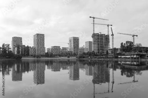 Skyscrapers and cranes reflect in river