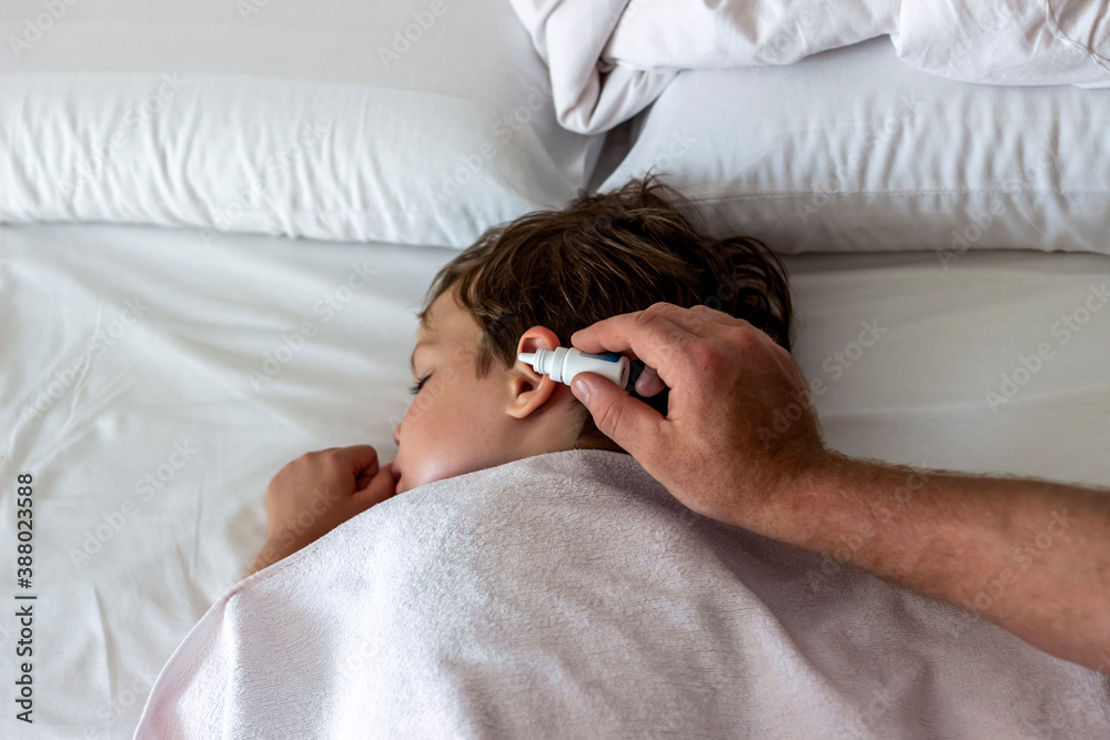 father-dribble-medication-into-boy-ear-photo-of-a-dad-dripping-ear