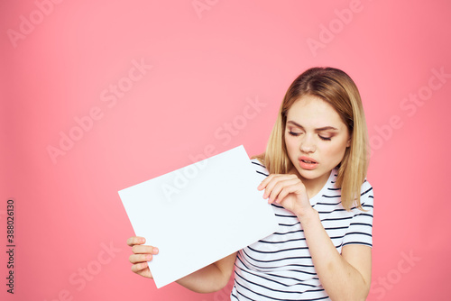 woman holding white sheet in her hands striped t-shirt emotions pink background