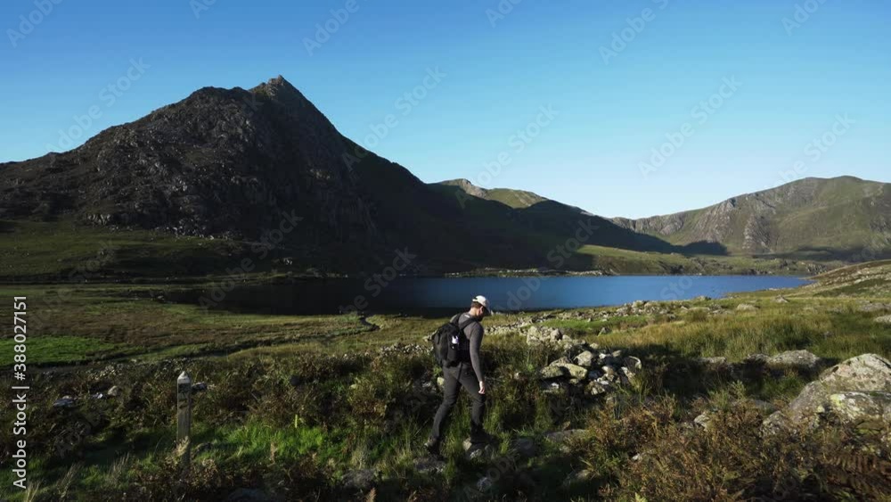 A man hiking through Snowdonia National Park in Wales A man hiking through Snowdonia National Park in Wales