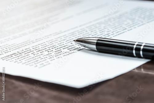 black pen on paper contract for signature on wooden desk