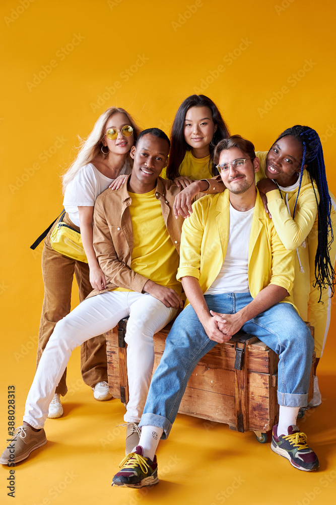 Obraz premium diversity, race, ethnicity and people concept. international group of happy friendly smiling men and women isolated on yellow background, studio shoot