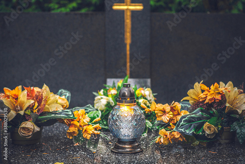 Fotografie a candle and orange flowers on the tomb on All Saints Day