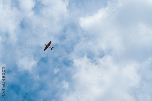 An airplane in the blue sky with beautiful clouds makes aerobatics.