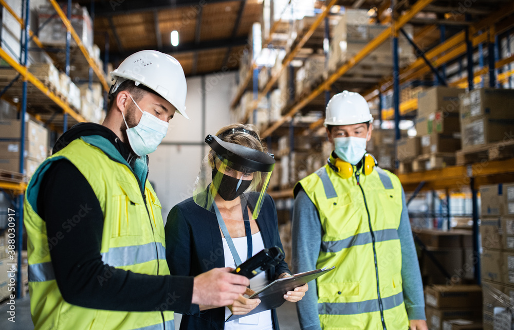 Group of workers with manager working indoors in warehouse, coronavirus concept. Group of workers with manager working indoors in warehouse, coronavirus concept.