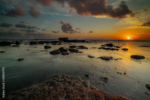 Amazing seascape. Beach with rocks and stones. Low tide. Motion water. Slow shutter speed. Soft focus. Mengening beach, Bali, Indonesia