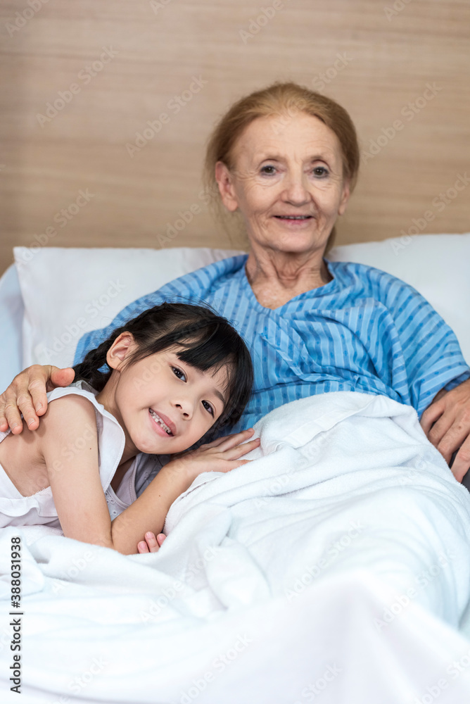 Asian Lovely girl visit and encourage grandmother on patient bed in hospital Asian Lovely girl visit and encourage grandmother on patient bed in hospital