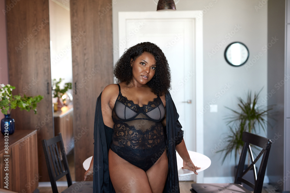 curly black afro woman stand indoors, in underwear and silk dressing gown.  newly awakened woman has happy morning Stock Photo | Adobe Stock
