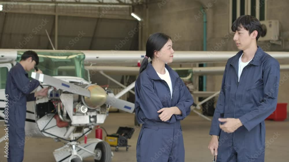 Portrait shot Team of young asian aircraft maintenance engineer standing in airplane hangar looking at camera with arms crossed. Portrait shot Team of young asian aircraft maintenance engineer standing in airplane hangar looking at camera with arms crossed.
