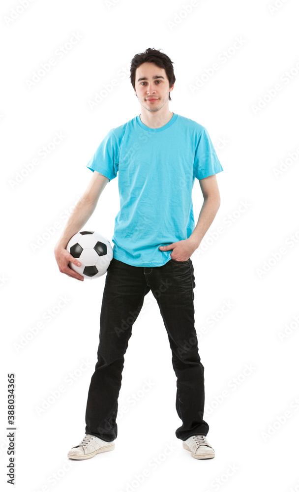 Young hispanic guy with blue t shirt standing holding a football. Studio photo, isolated on white background. 