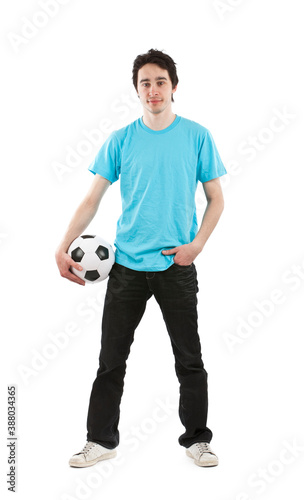 Young hispanic guy with blue t shirt standing holding a football. Studio photo, isolated on white background. 