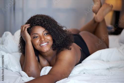 afro american overweight woman enjoy weekends at home on bed, every morning is good. sensual pretty lady in underwear, relax