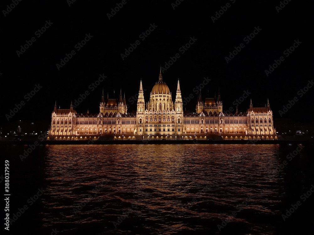 illuminated Budapest Parliament at night from a ship