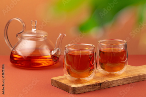 Glass teapot and two glass cups with tea