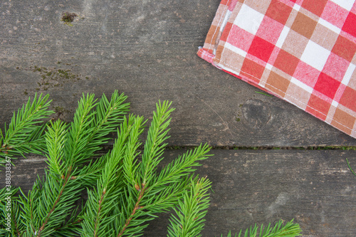 Fir branch and checkered towel on a old wooden table photo