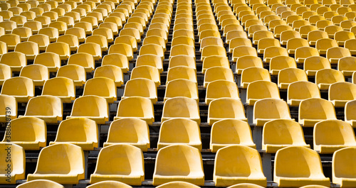 seats of tribune on sport stadium. empty outdoor arena. concept of fans. chairs for audience. cultural environment concept. color and symmetry. empty seats. modern stadium. yellow tribunes