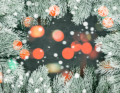 Christmas background with frozen winter fir garland border and snow on black