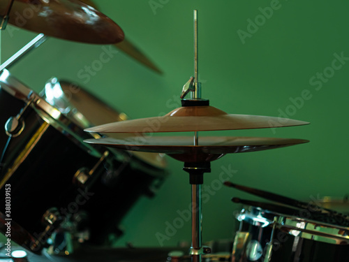 Black drum kit close-up. Musician set with mix of drums in studio. Musical instruments devices for drumming performance. Low key, dark and moody rock metal music style. Selective focus on cymbals.