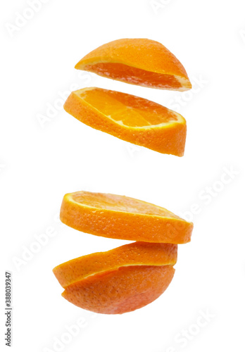 Flying pieces of a sliced orange isolated on white background