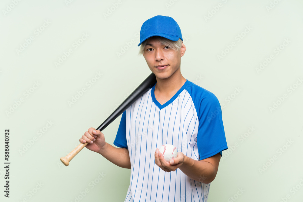 Young asian man playing baseball over isolated green background Young asian man playing baseball over isolated green background