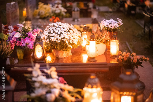 candles and white flowers on the tomb on All Saints' Day
 photo