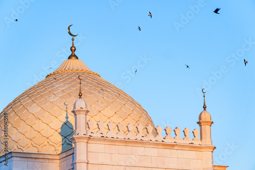 birds fly around the dome of the white mosque in Bolgar