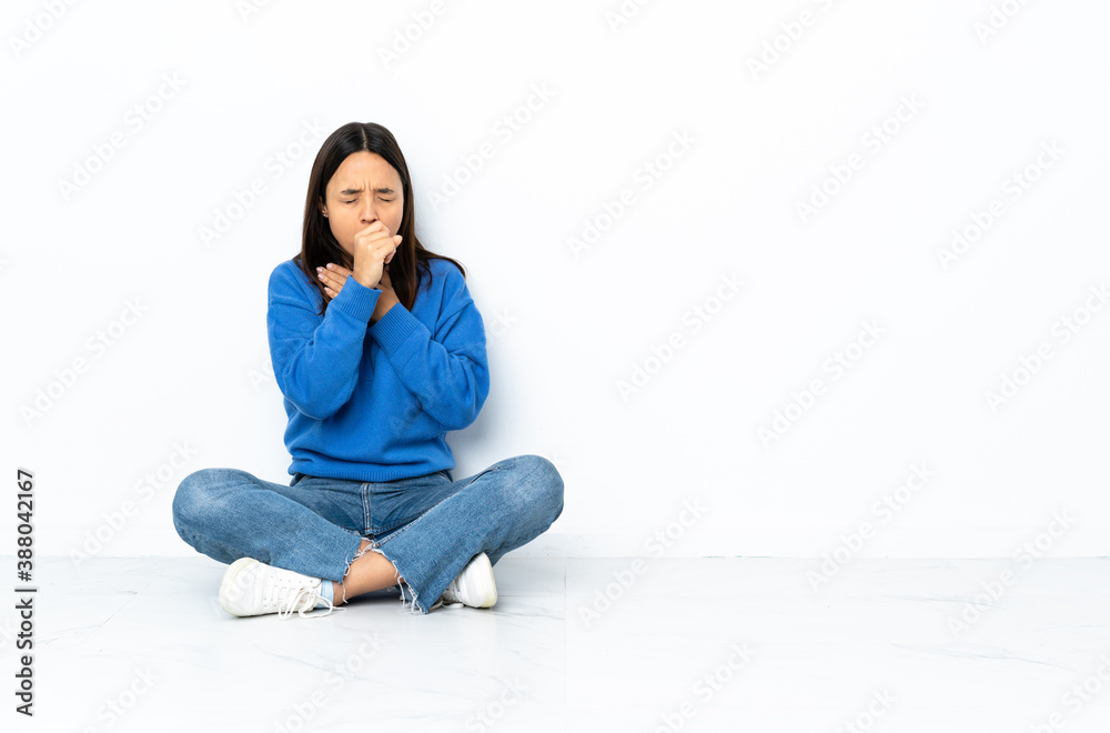 Young mixed race woman sitting on the floor isolated on white background coughing a lot Young mixed race woman sitting on the floor isolated on white background coughing a lot