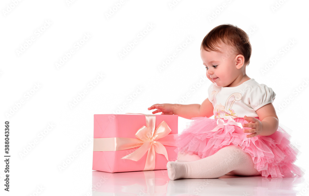 Girl sitting on the floor with a gift box and smiling. Girl sitting on the floor with a gift box and smiling.