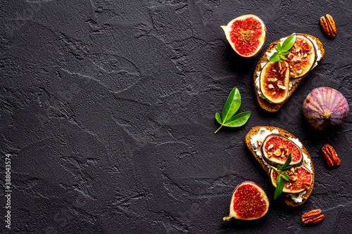 Sandwiches with figs, cheese and honey on table
