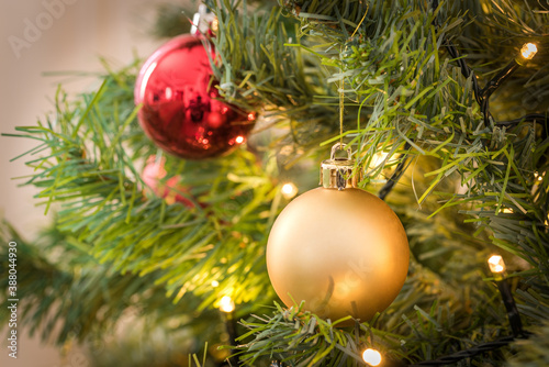 Close up of a Christmas tree with colourful baubles and lights. Selective focus and copy space. photo