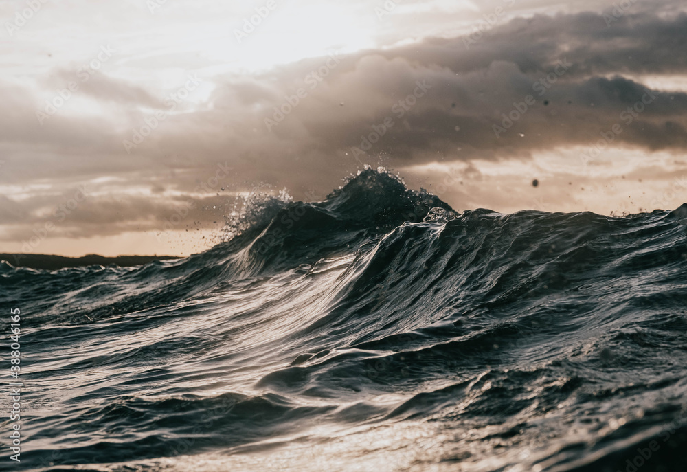 moody waves crash with sun breaking through - obrazy, fototapety, plakaty 