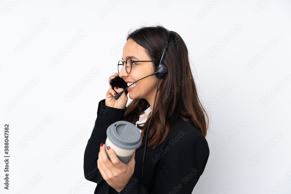 Young telemarketer woman isolated on white background holding coffee to take away and a mobile Young telemarketer woman isolated on white background holding coffee to take away and a mobile