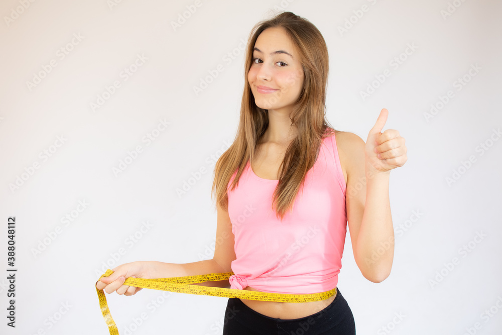 Woman holding tape measure around waist - Stock Image - F020/7701
