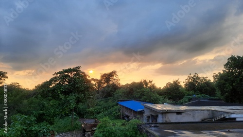 Indian village sunset scene above house roofs © luckbs