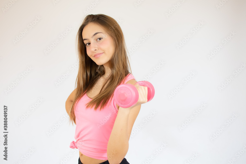 Attractive young fitness woman holding dumbbell. Studio shot. Attractive young fitness woman holding dumbbell. Studio shot.