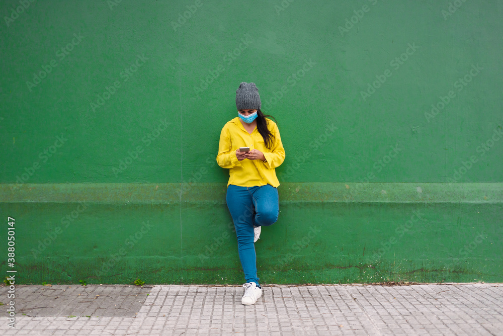 Young Girl Using face mask and Phone in Street