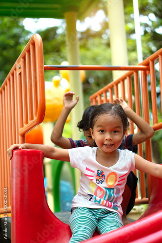Asian girl is enjoy on a playground equipment in a school.