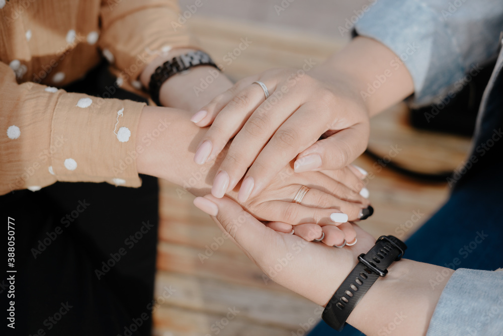 Two young adult lesbian women holding hands. Women's hands close up Two young adult lesbian women holding hands. Women's hands close up
